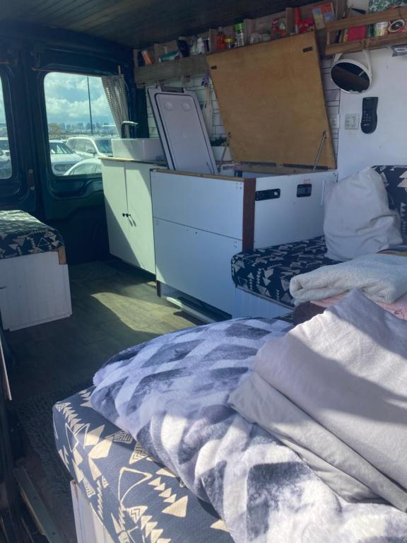 カイルアにあるOahu Camper Adventuresのベッド、デスク、デスクが備わる客室です。