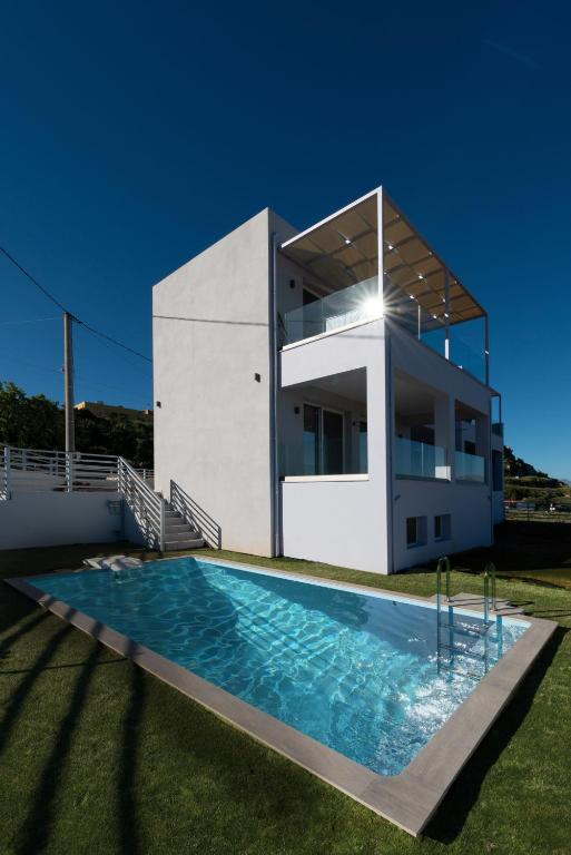 a villa with a swimming pool in front of a house at Villa P3 Paradise in Arménoi