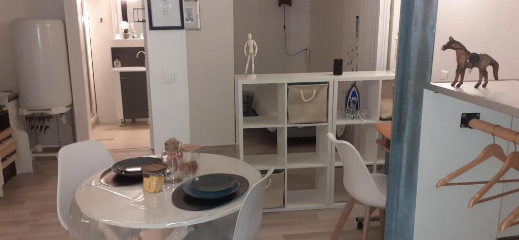 ein Esszimmer mit einem weißen Tisch und einem Pferd auf einem Regal in der Unterkunft Studio Chavigny avec wifi in Chavigny