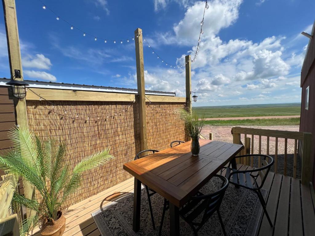 a wooden deck with a wooden table and chairs at Angostura Oasis in Hot Springs