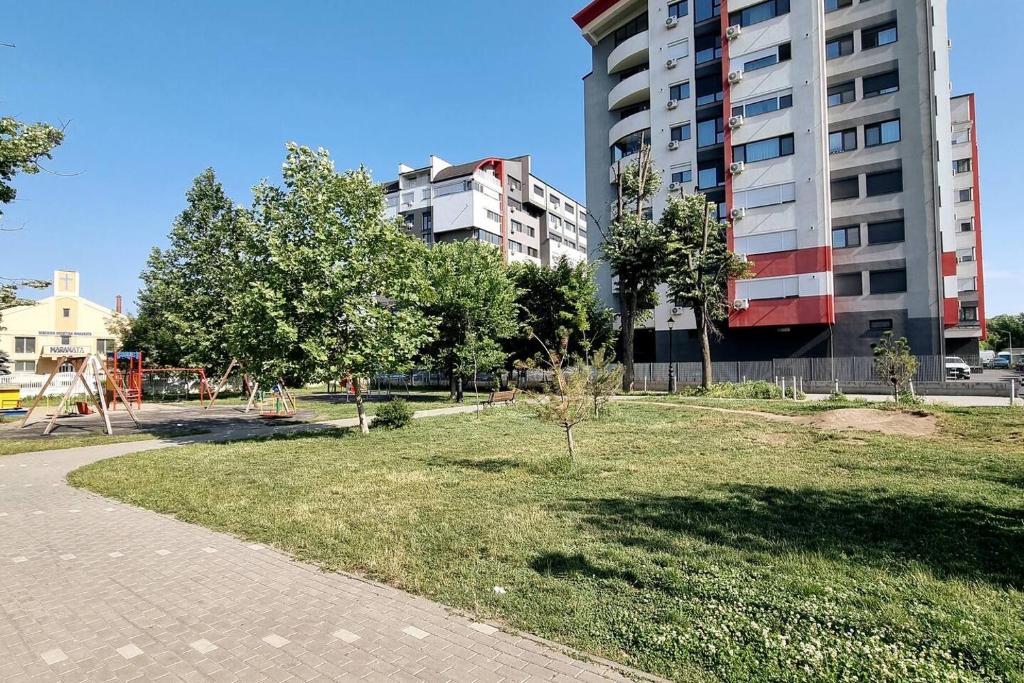 um parque com uma área relvada e um edifício em Bijou Aparthotel em Galaţi