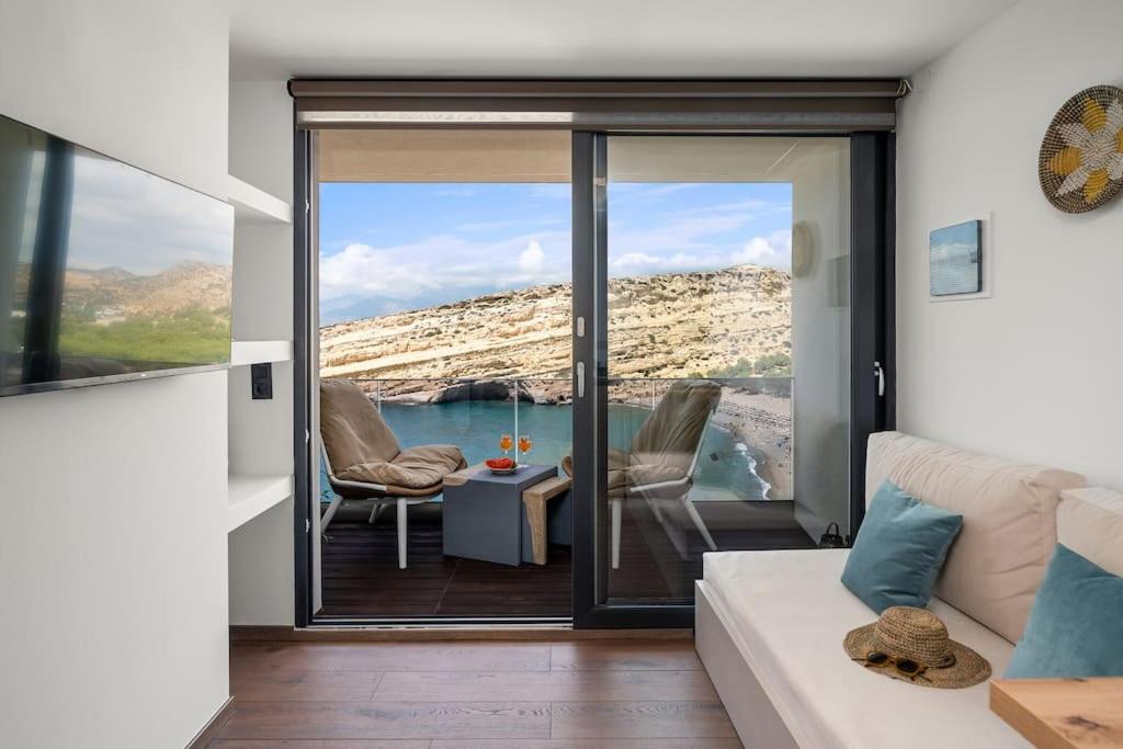 a living room with a couch and a view of the ocean at Nieva Apartment 2 in Matala