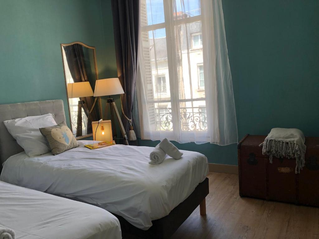 a bedroom with two beds and a window at Hypercentre - Coté Chateau in Blois