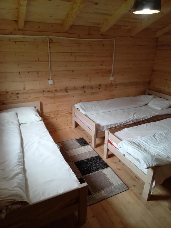 a room with three beds in a wooden cabin at Dedushi Guesthouse &Wood cabins-Camping place in Gusinje
