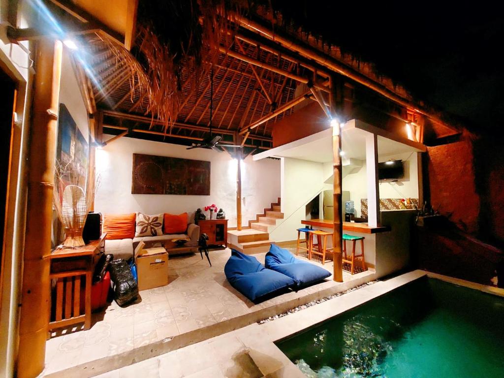 a room with a swimming pool and a living room at Happiness Villa 1BR+Private Pool @Seminyak in Seminyak