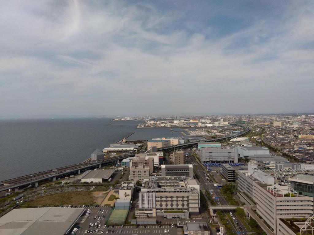 an aerial view of a city next to the water at Odysis Suites Osaka Airport Hotel in Izumi-Sano