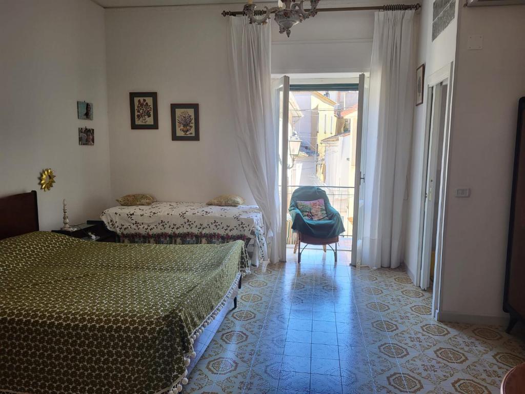 a bedroom with two beds and a chair and a window at Casa Del Fico in Montecorice