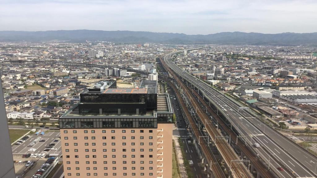 an aerial view of a city with train tracks at Odysis Suites Osaka Airport Hotel in Izumi-Sano