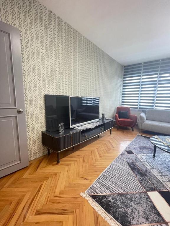 Smf Suites 2+1 5 Luxery Flat Good Location في إسطنبول: غرفة معيشة مع تلفزيون بشاشة مسطحة كبيرة