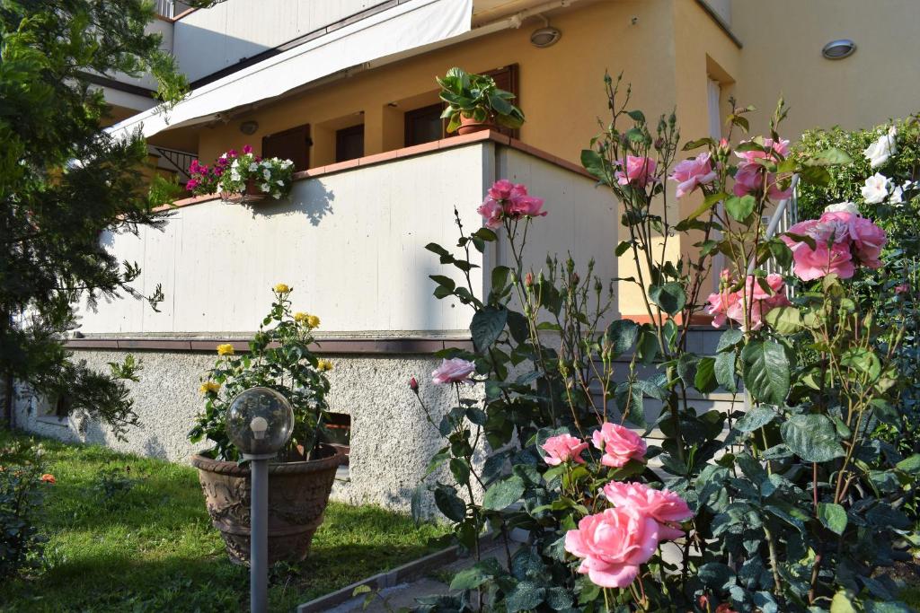 a garden with pink flowers and a building at La Casa di LiLi in Pontassieve
