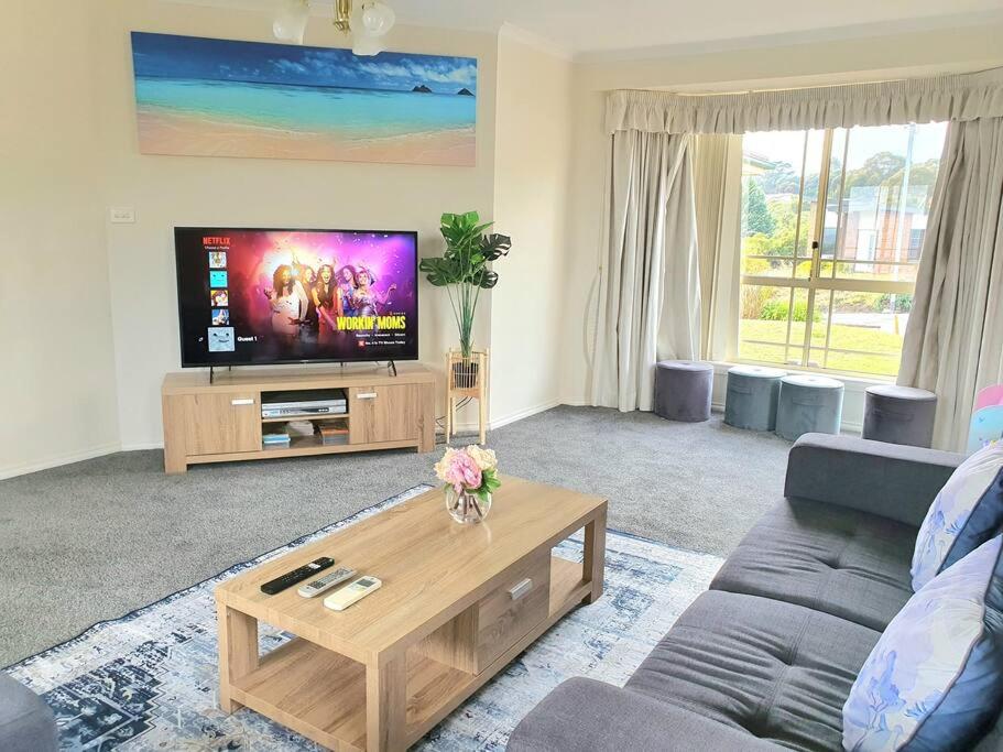 a living room with a couch and a tv at Spacious Home in West Moonah, Hobart in Moonah