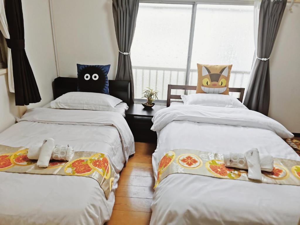1 dormitorio con 2 camas con ojos en ellas en totoro house, en Musashino