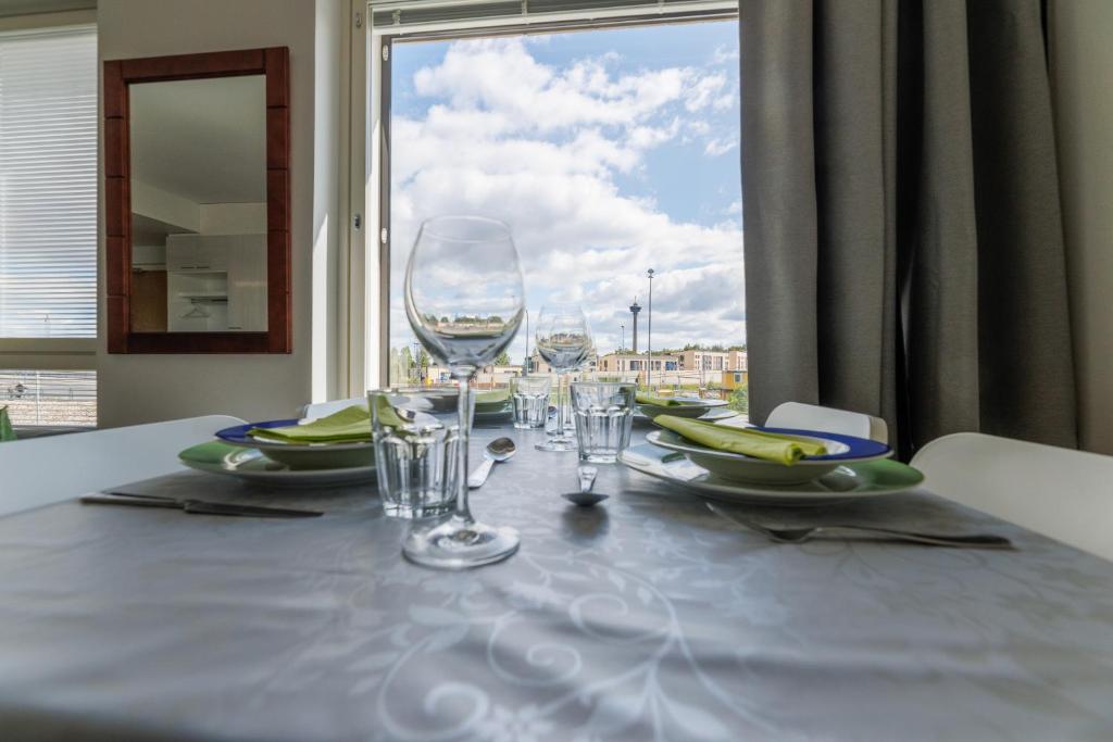 a table with wine glasses on a table with a window at Close to center and Näsijärvi Lake - free parking, AC, and two double beds in Tampere