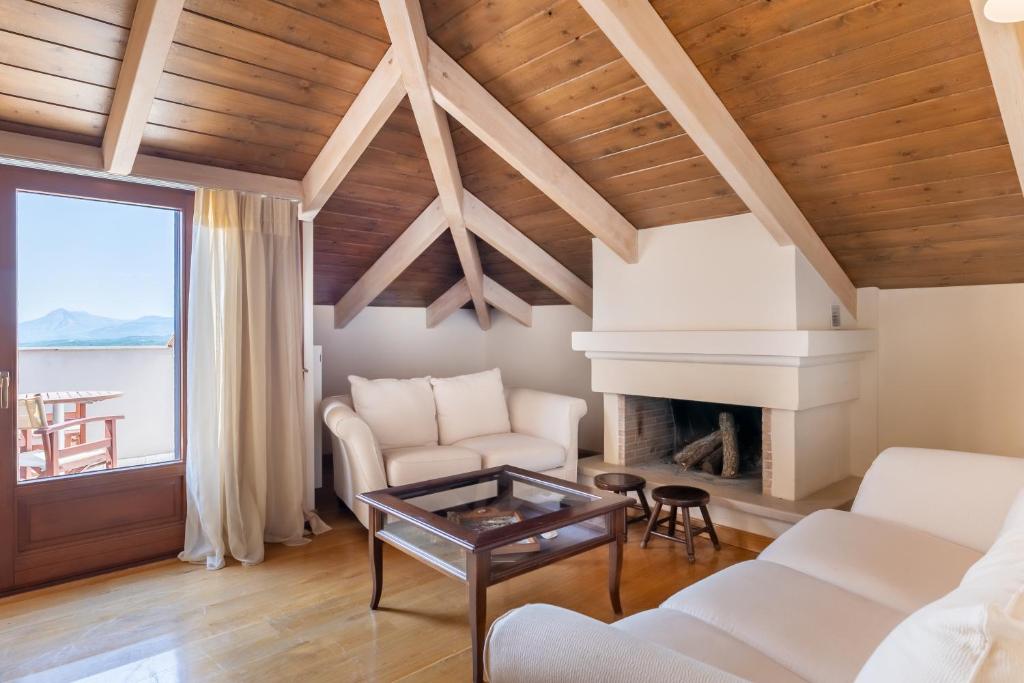 a living room with white furniture and a fireplace at Konitsa Mountain Hotel in Konitsa