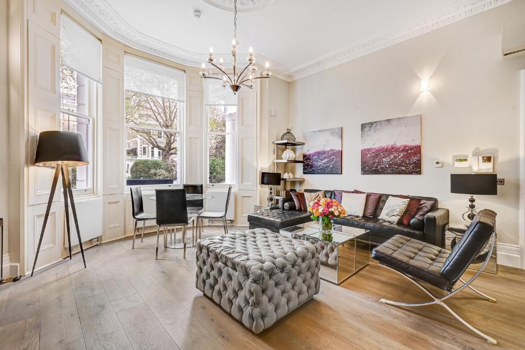 een woonkamer met een bank en een tafel bij The One South Kensington in Londen