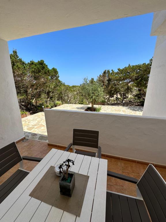 een eetkamer met een tafel en stoelen op een balkon bij AT Espalmador Formentera rustick in Es Pujols