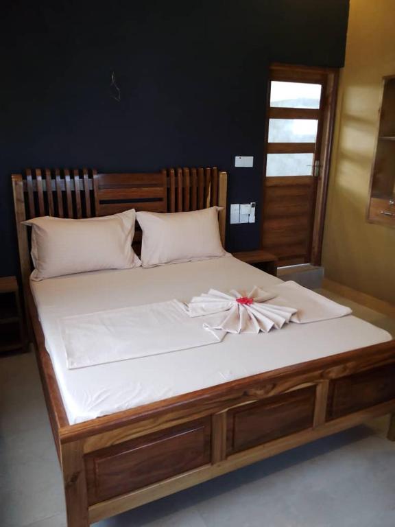 a white bed with a bow on top of it at Panopano House in Nungwi