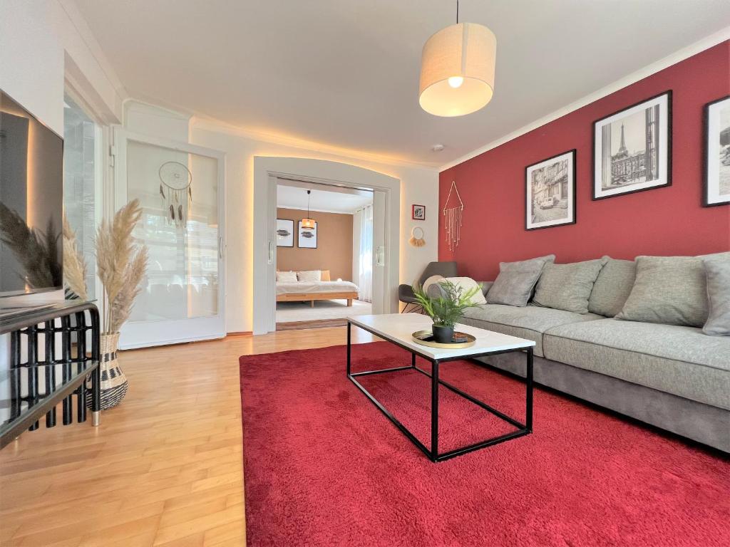 sala de estar con sofá y pared roja en NEU! Charmantes 3 Zimmer Korbstadt-Apartment, Terrasse, Wanderwege, optimale Anbindung, en Lichtenfels