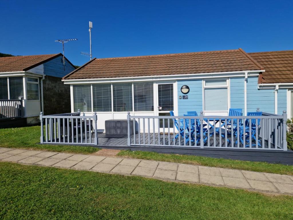 a blue house with a white fence and a porch at Surfs Up Lodge - Westward Ho! in Westward Ho