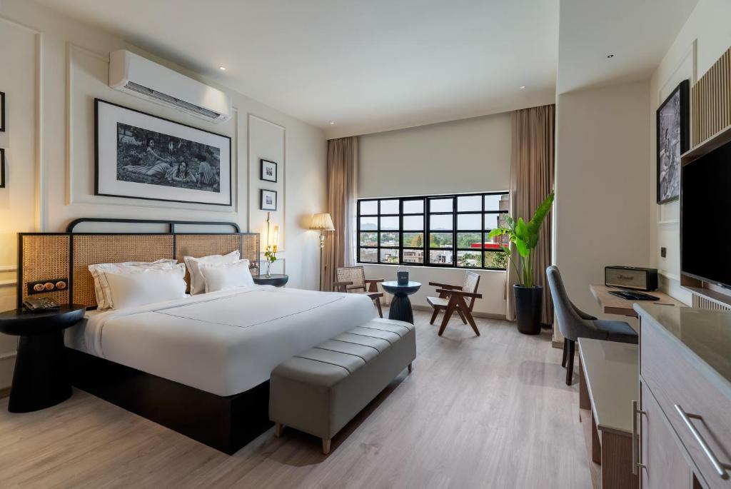a bedroom with a large white bed and a desk at My Downtown - Prime A Premium Boutique Hotel Udaipur in Udaipur