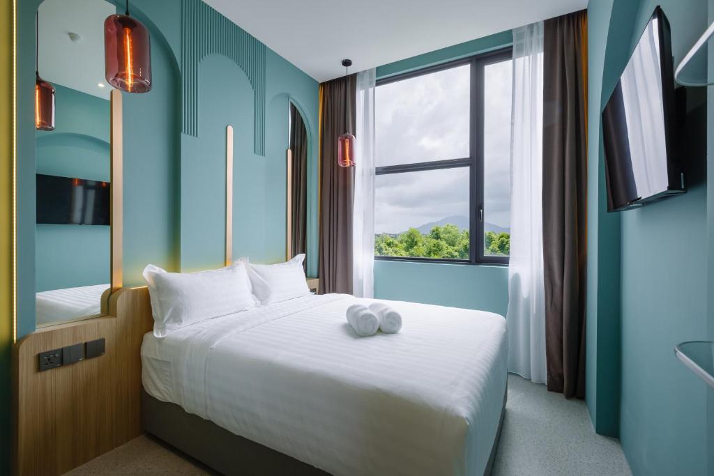 - une chambre avec un grand lit et une fenêtre dans l'établissement Wellesley Hotel, à Simpang Ampat