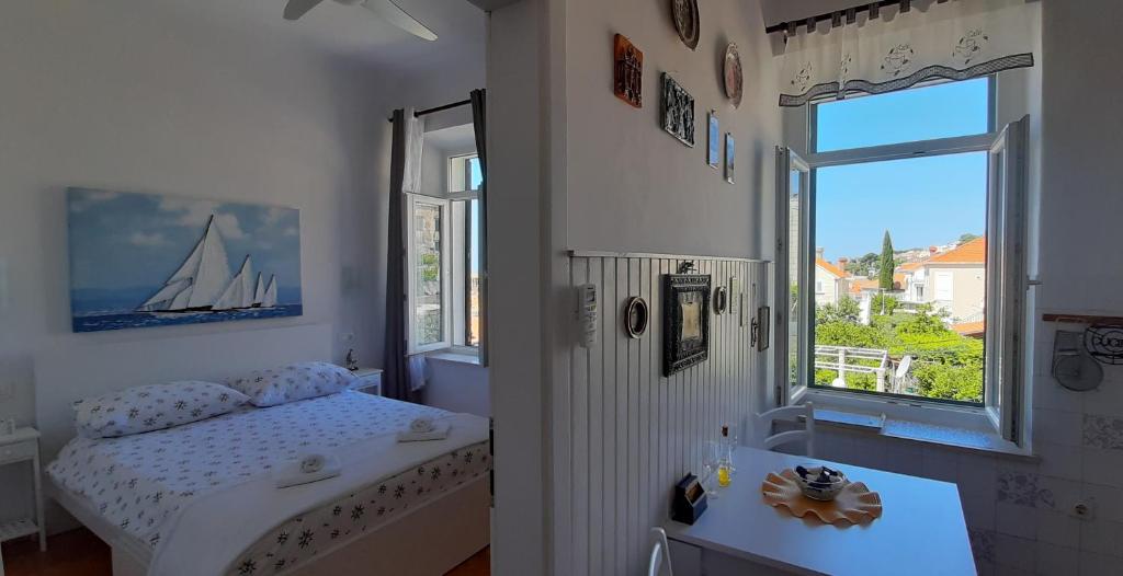 a small bedroom with a bed and a window at Studio Apartment NIKO II 5 min to center in Dubrovnik