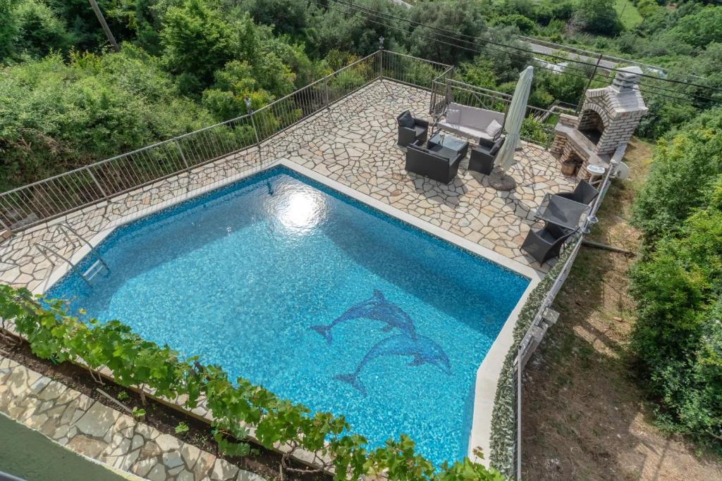 una vista aérea de una piscina con 2 sillas de patio y una piscina en Villa Montenegrina, en Petrovac na Moru