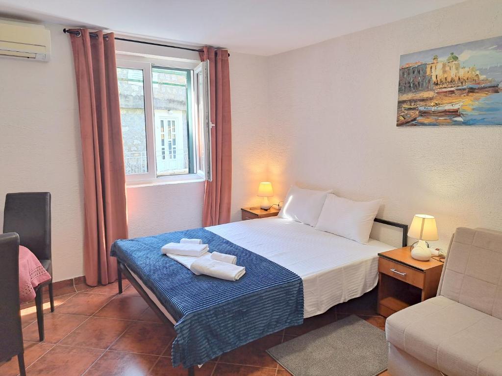 een slaapkamer met een bed met twee handdoeken erop bij Guest House Plan B in Rafailovici