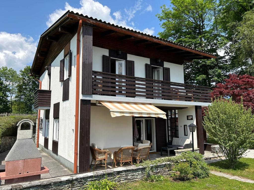 a house with a balcony and chairs in the yard at COSY VINTAGE HOUSE in Bled