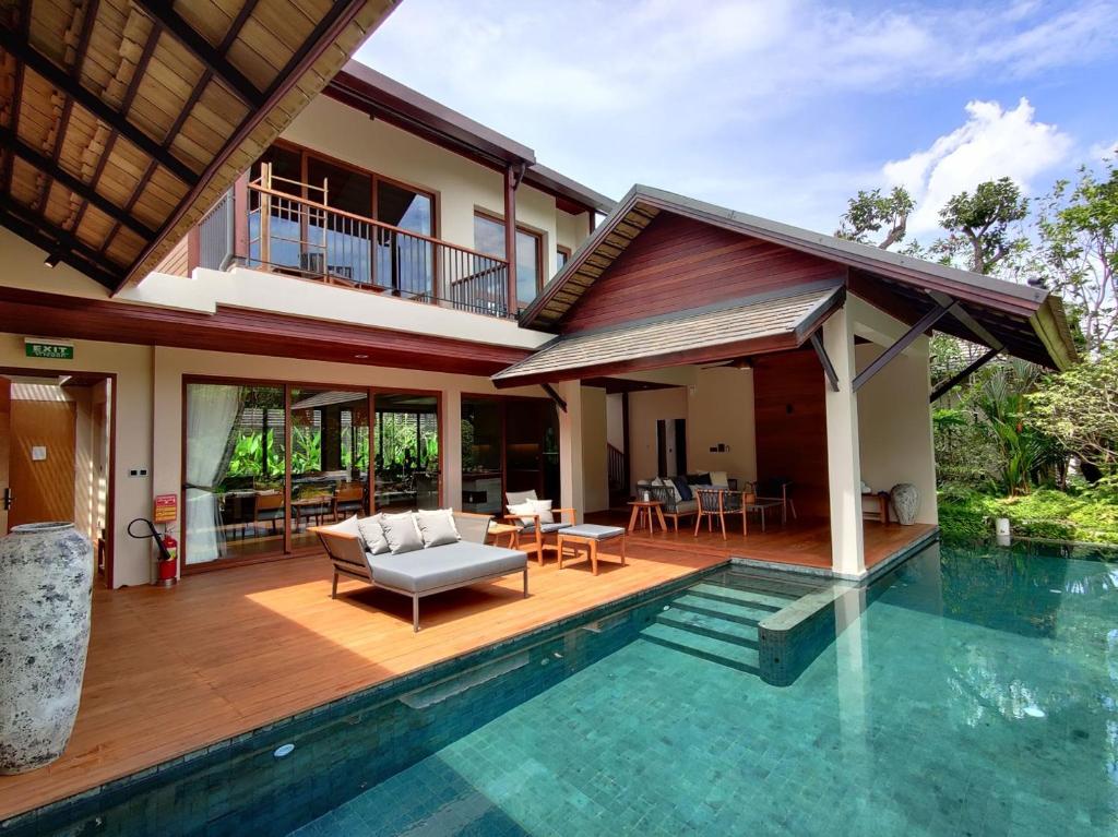 a villa with a swimming pool and a house at Rarin Villas in Chiang Mai