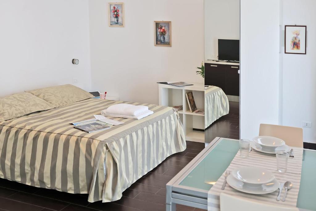 sypialnia z łóżkiem i stołem z płytami w obiekcie Casa Vacanze Aurora Centro w Rimini