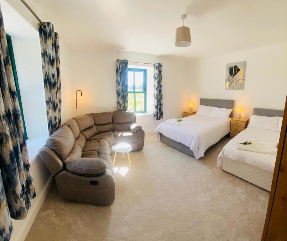 a living room with two beds and a couch and a bed at Farmhouse in Virginia County Cavan in Cavan