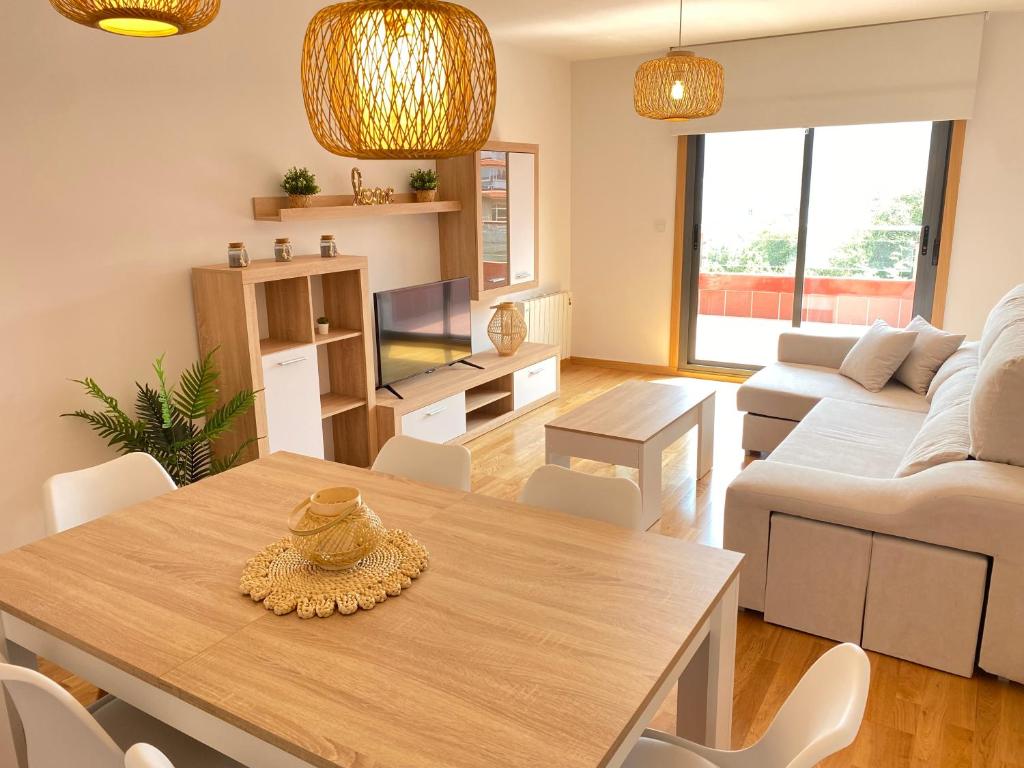 sala de estar con mesa y sofá en PreaMar apartamento acogedor con terraza, en Laxe