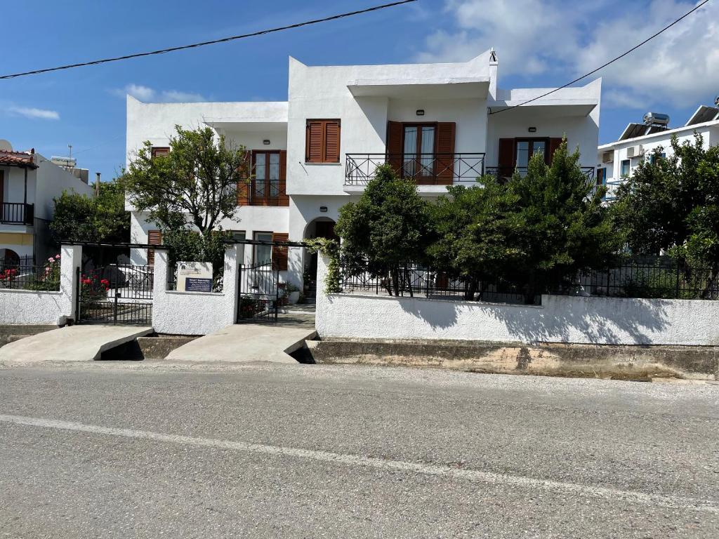 una casa bianca sul lato di una strada di Karagiozos Studios & Apartments a Skopelos Town