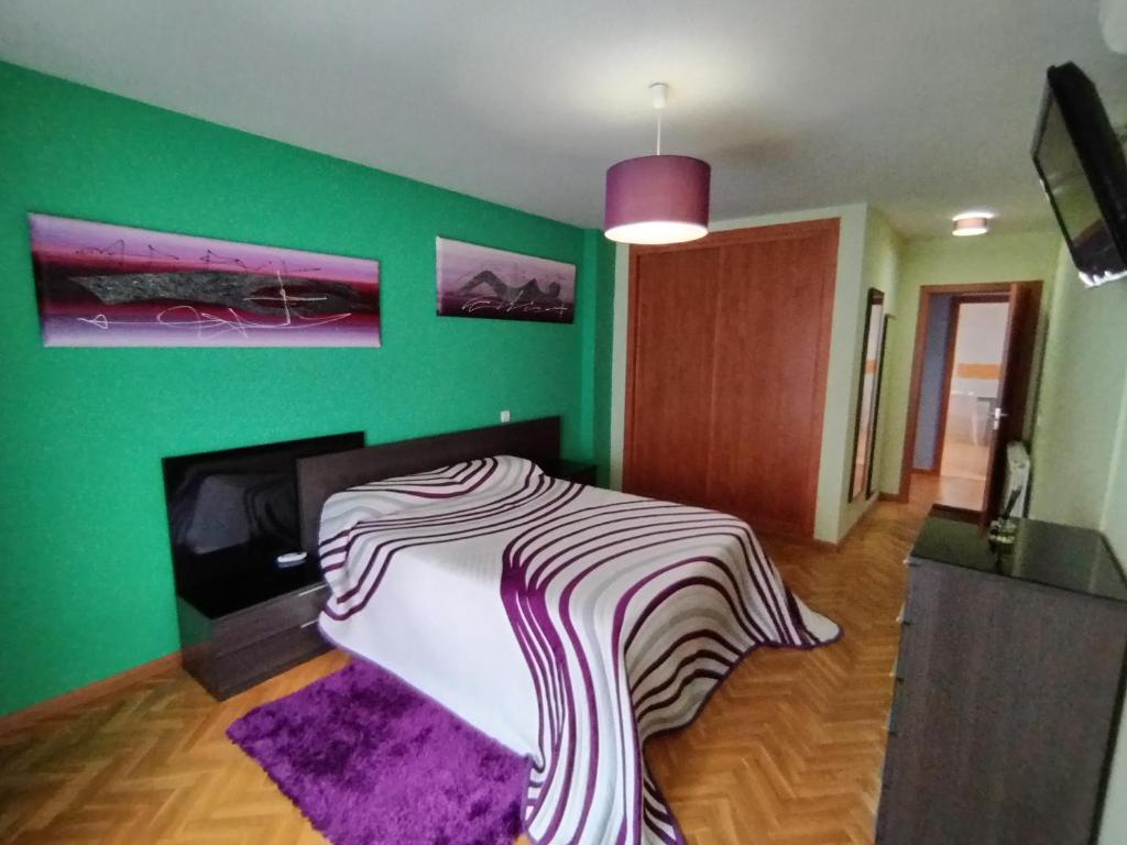 ein Zimmer mit einer grünen Wand und einem Bett darin in der Unterkunft Apartamento El Alfar in Talavera de la Reina