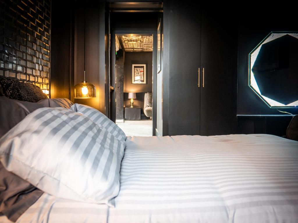 1 dormitorio con cama blanca y pared de ladrillo en The Sea Lounge Accomodation, en Broadstairs