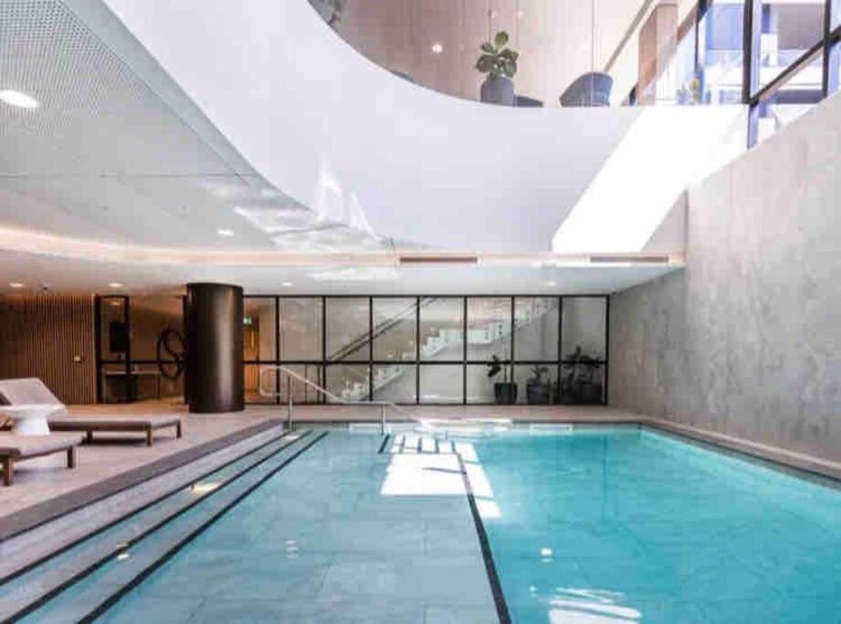 a large swimming pool in a building with a large ceiling at Welcome to Skyview - top level in Glen Waverley