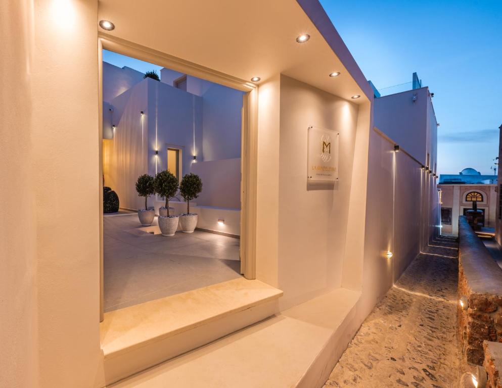 a mirror on the side of a building with potted plants at La Madeleine in Oia