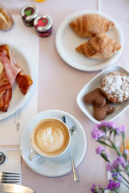 a table with plates of pastries and a cup of coffee at Abc Hotel in Thessaloniki