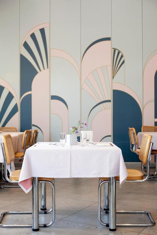a table with a white table cloth on it in a room with chairs at Abc Hotel in Thessaloniki
