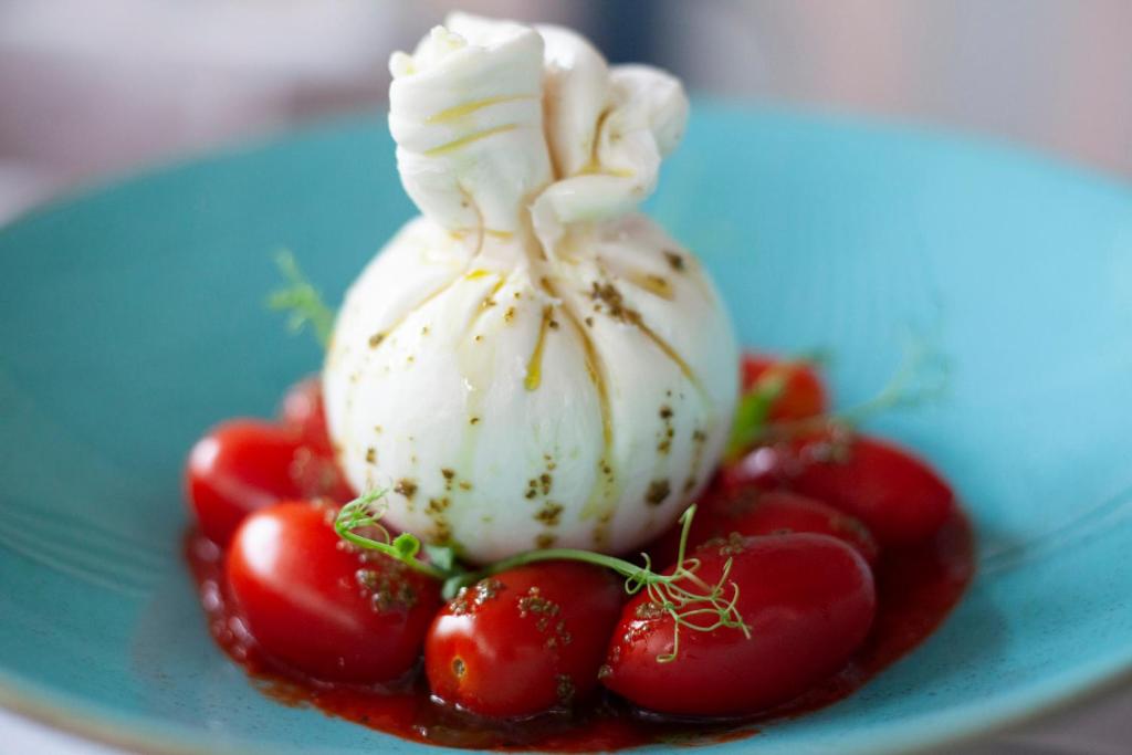 a dessert with whipped cream and strawberries on a blue plate at Abc Hotel in Thessaloniki