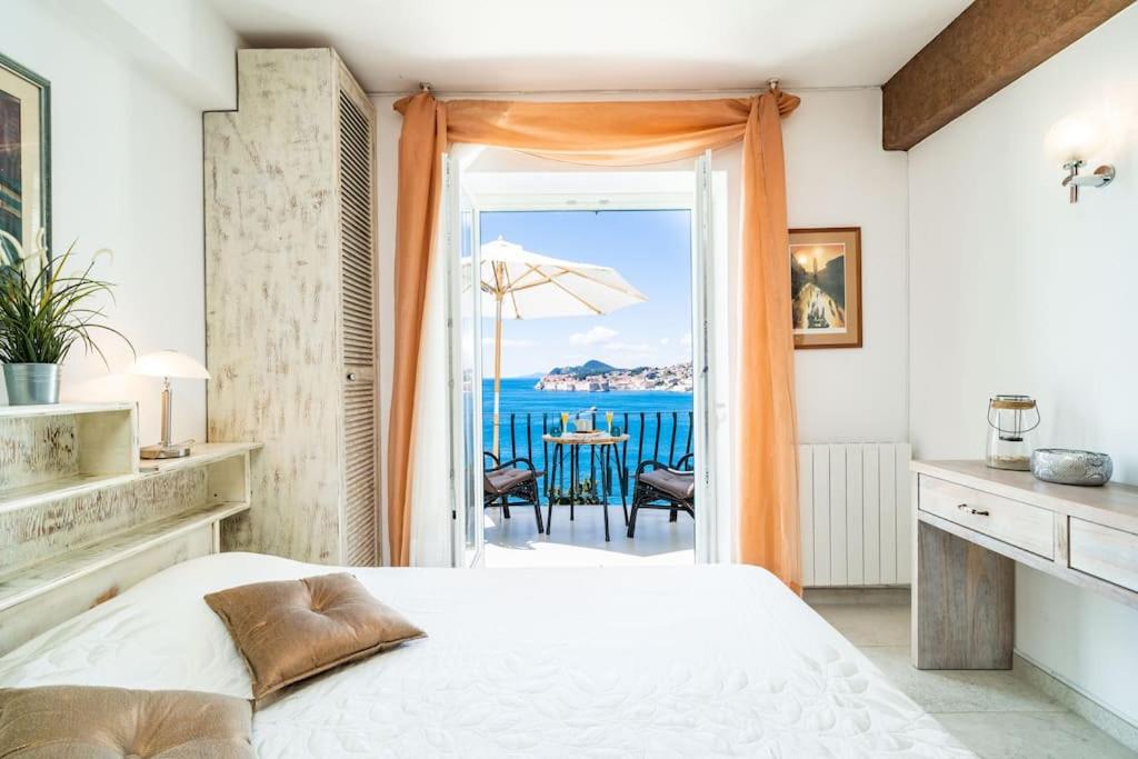 a bedroom with a bed and a view of the ocean at Beach House Sveti Jakov 1 in Dubrovnik