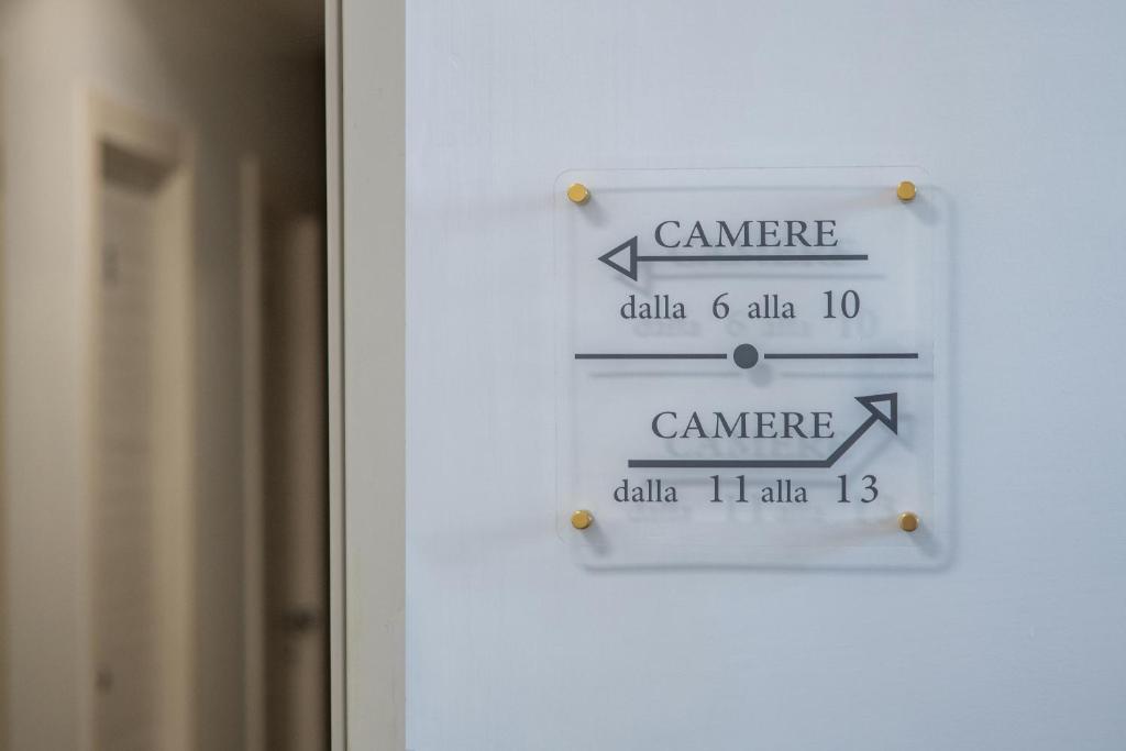 a sign on a door with arrows pointing in different directions at Gu Hotel in Guidonia