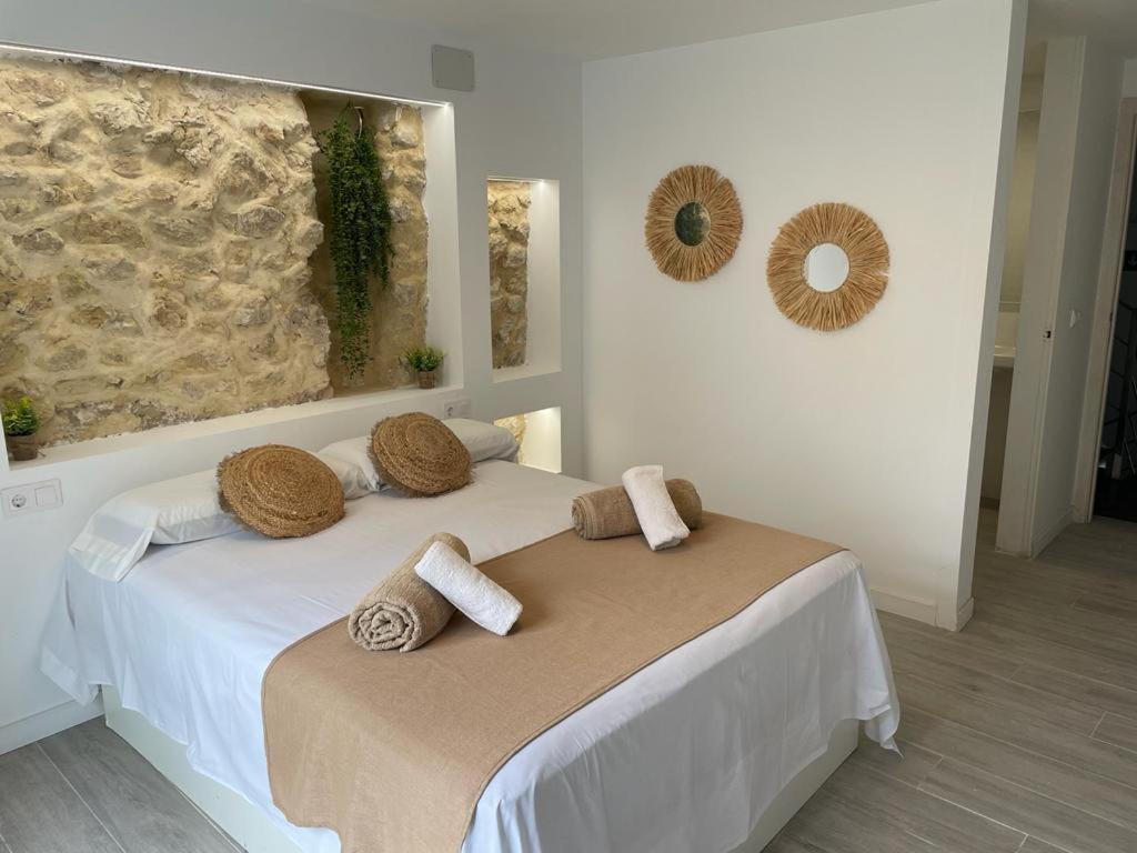 Un dormitorio con una cama con almohadas. en Ereta Rooms Habitaciones baño privado, en Alicante