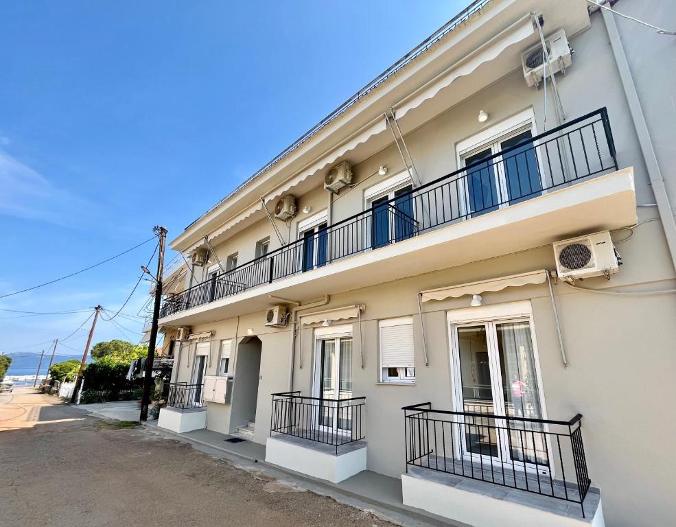 a white building with balconies on a street at Diana Studios in Pefki