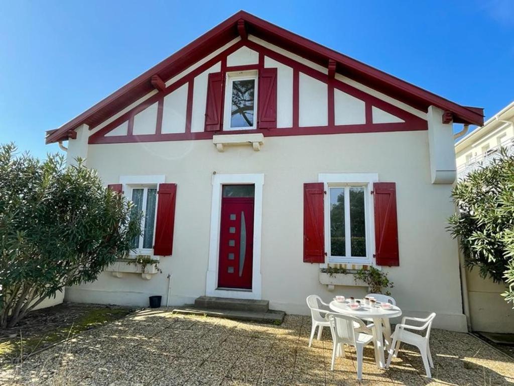 ein weißes Haus mit einer roten Tür und einem Tisch in der Unterkunft Appartement Capbreton, 2 pièces, 4 personnes - FR-1-413-111 in Capbreton