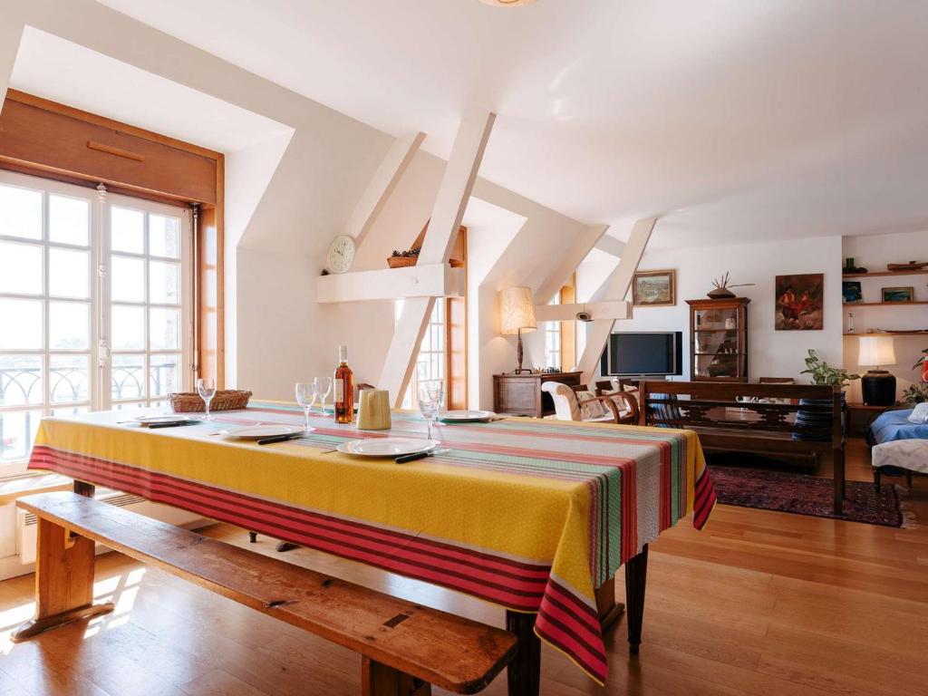 un salon avec une table et un tissu de table rayé dans l'établissement La Trinité/Mer, appt spacieux 4p, 100m², 3 ch, wifi, animaux admis - FR-1-477-79, à La Trinité-sur-Mer