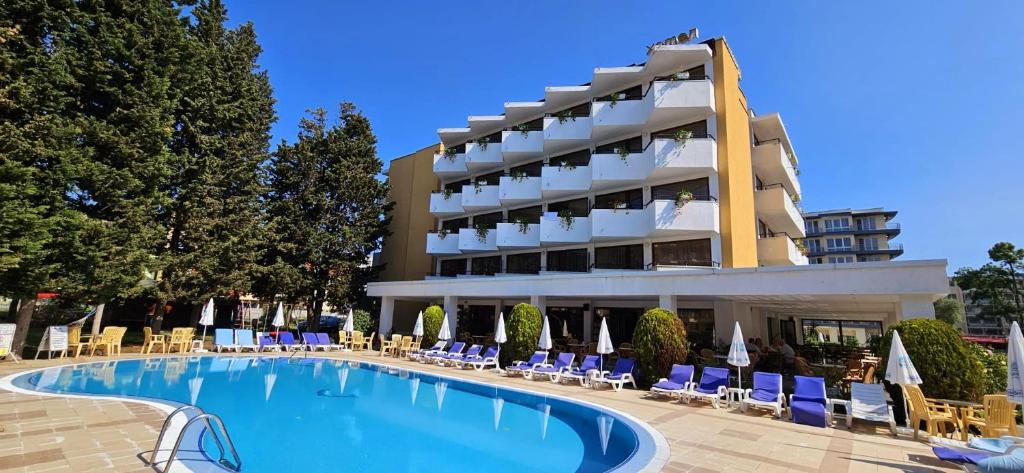 a hotel with a swimming pool in front of a building at Hotel Klisura in Sunny Beach