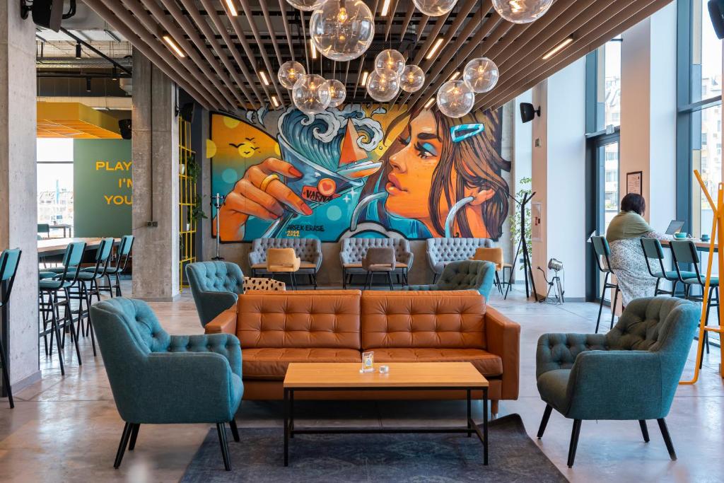 a lobby with a couch in front of a mural at Hotel Campus 90 - Free Parking in Varna City