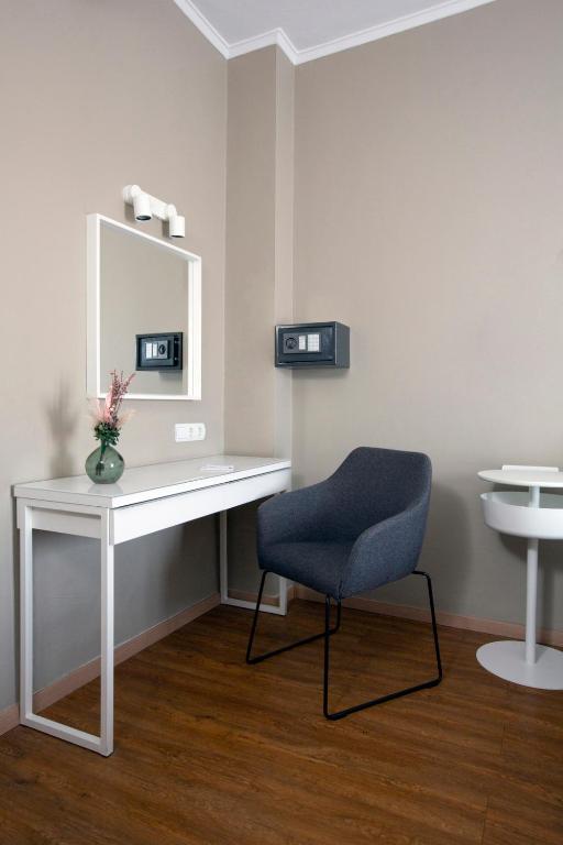 a white desk with a chair and a mirror at Abc Hotel in Thessaloniki